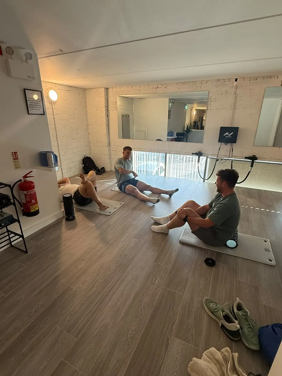 Guests stretching on the mobility floor, the fire extinguisher and rack by the wall